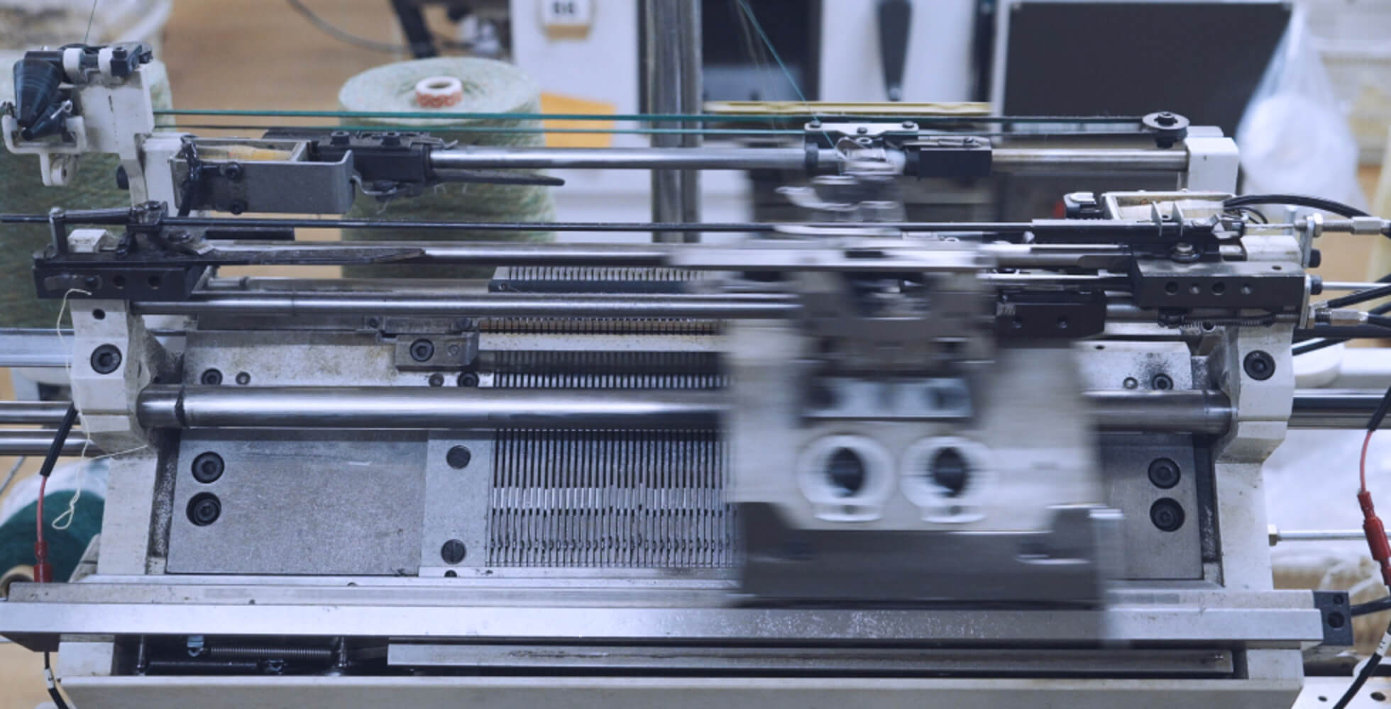 上部のキャリッジが高速で左右に動き、ニットが編まれていく